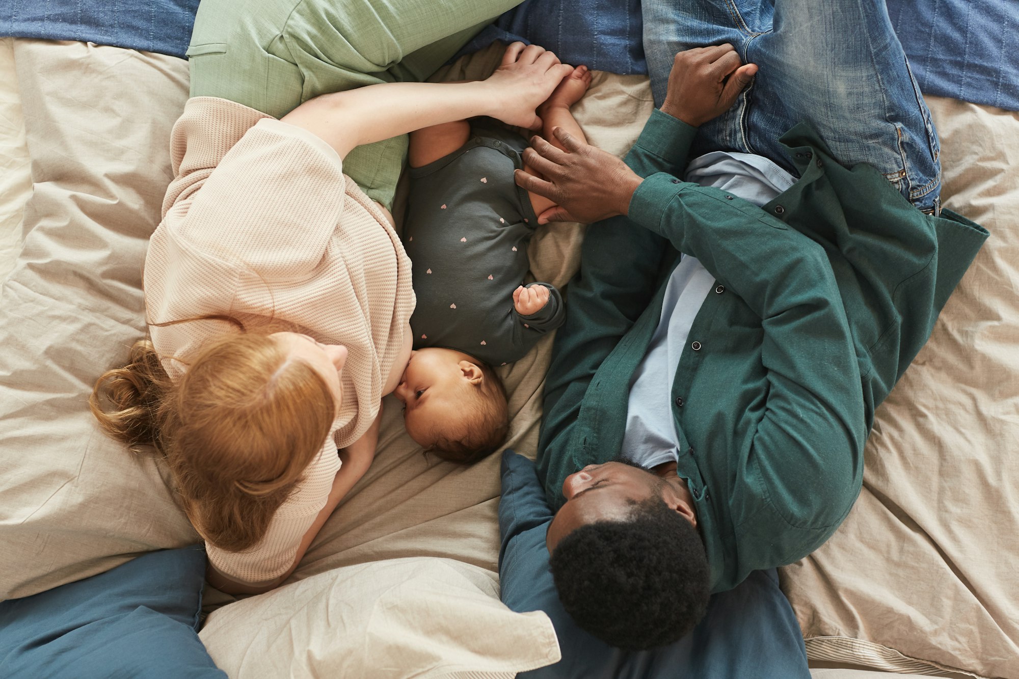 Happy Mixed race Family with baby on Bed