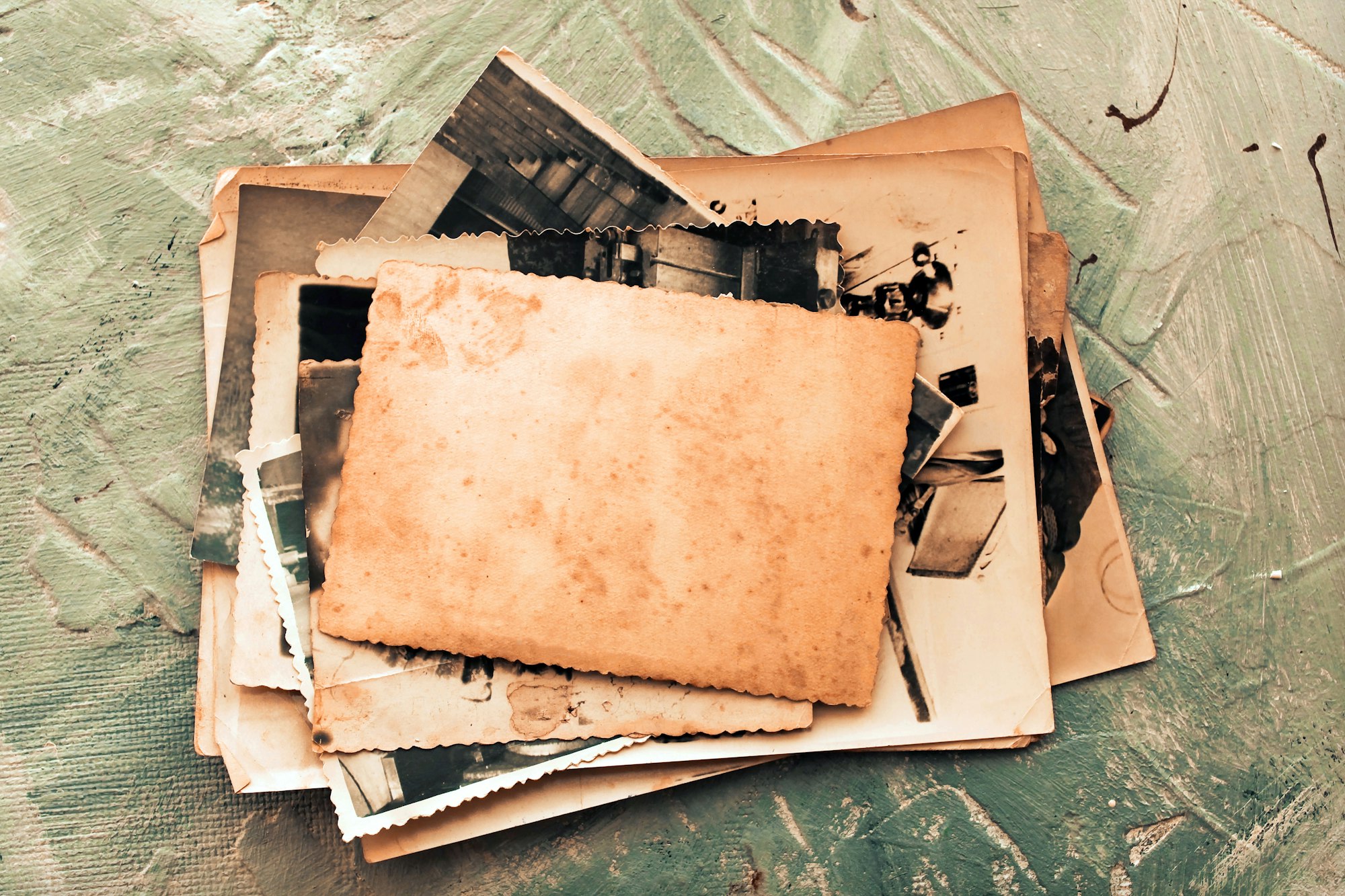 Stack old photos on grey background. Postcard rumpled and dirty vintage.